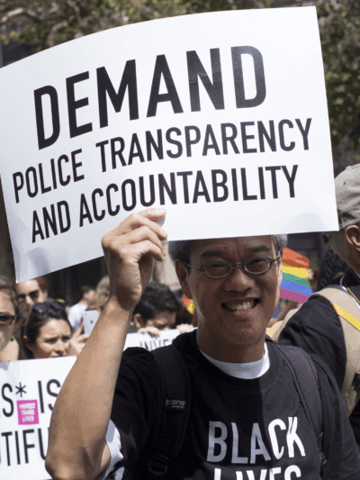 Marcher-with-Demand-Police-Transparency-sign.png