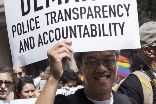 Marcher-with-Demand-Police-Transparency-sign.png