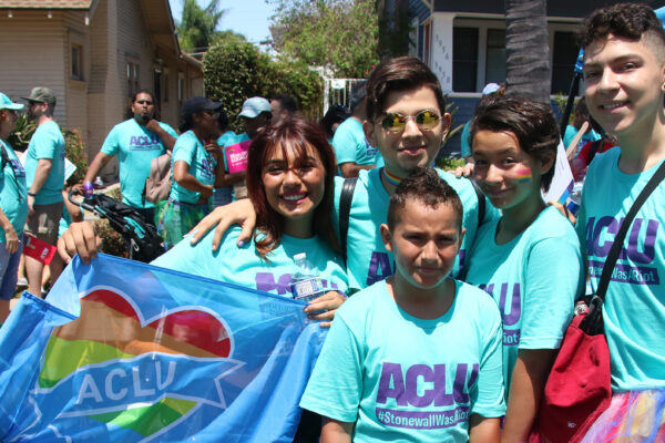 Five young people in ACLU teal shirts posing for a picture.