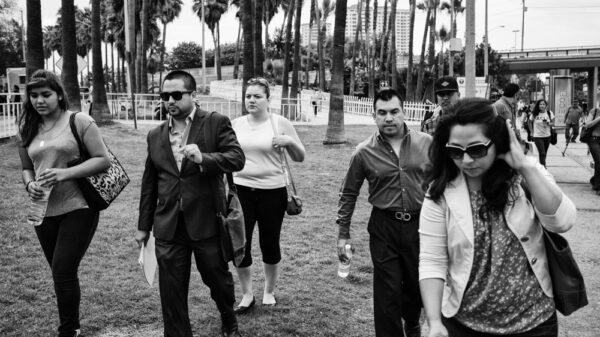 Black and white image of people walking toward the camera with