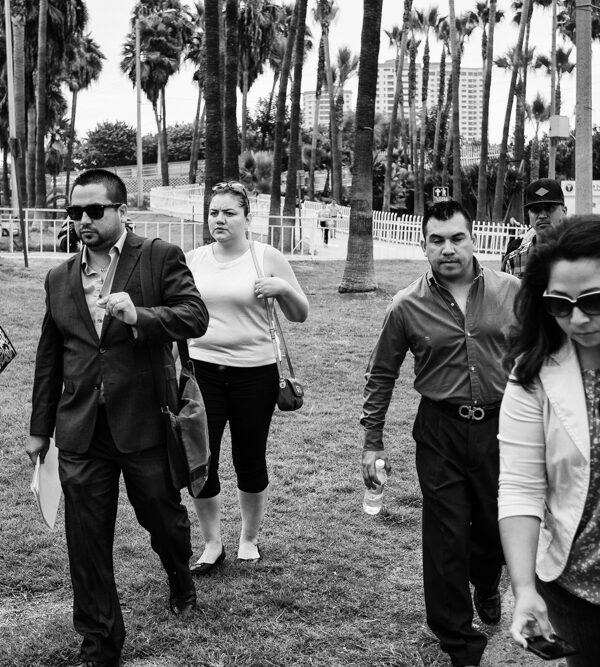 Black and white image of people walking toward the camera with