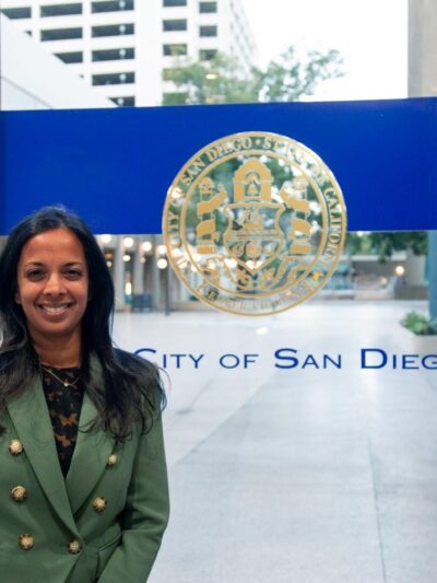 Nalini stands in front of City of San Diego emblem