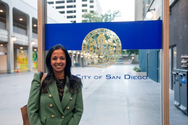 Nalini stands in front of City of San Diego emblem