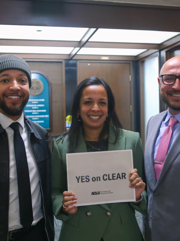 Jeff, Nalini and Eddie in the San Diego County Administrative Building. Nalini is holding a "Yes on CLEAR" sign.