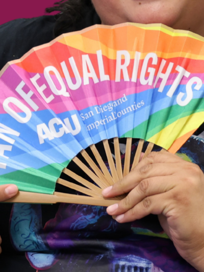 Daniela holding rainbow fan that says "fan of equal rights"