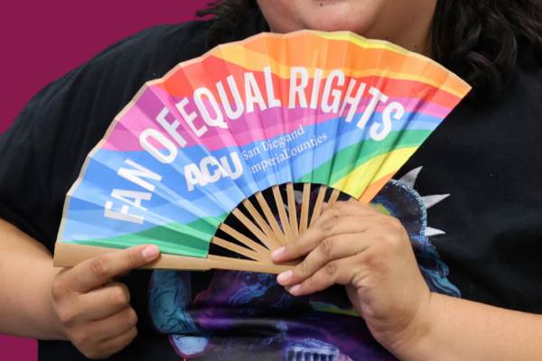 Daniela holding rainbow fan that says "fan of equal rights"