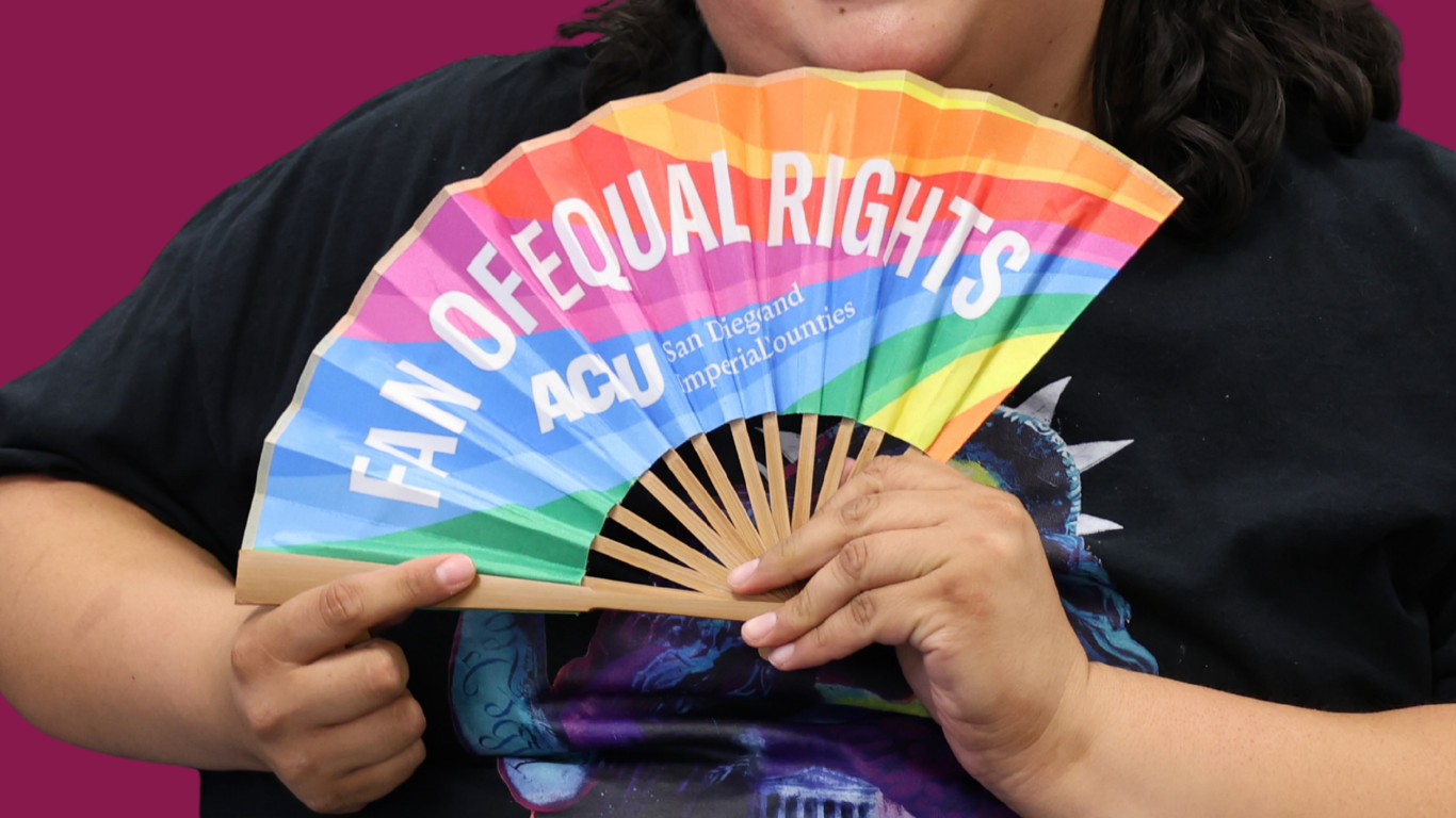 Daniela holding rainbow fan that says "fan of equal rights"