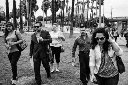 Black and white image of people walking toward the camera with